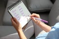 Pregnant woman with baby names list sitting on sofa Royalty Free Stock Photo