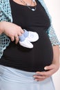 Pregnant woman with baby socks in hand on white Royalty Free Stock Photo