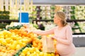 Pregnant woman with bag buying oranges at grocery Royalty Free Stock Photo