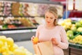 Pregnant woman with bag buying oranges at grocery Royalty Free Stock Photo