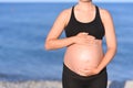 Pregnant woman beach - hands in heart shape on belly Royalty Free Stock Photo