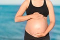 Pregnant woman beach - hands in heart shape on belly Royalty Free Stock Photo
