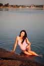 pregnant woman on the beach, Smiling, beautiful pregnant woman in pink swimsuit posing on the sandy beach of the river Royalty Free Stock Photo