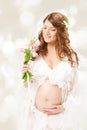 Pregnant woman. Beautiful pregnancy: long curly hair and chiffon