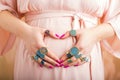 Pregnant woman with beautiful rings showing heart sign Royalty Free Stock Photo