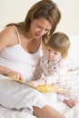 Pregnant woman in bedroom reading book with daught Royalty Free Stock Photo