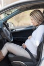 Pregnant woman behind the steering wheel having contractions Royalty Free Stock Photo