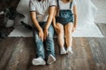 A pregnant woman with a belly and her husband sitting on the couch and holding hands. Royalty Free Stock Photo