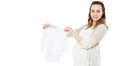 Pregnant woman with belly shows baby clothes on white