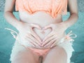 Pregnant woman belly in swimming pool. expectant mother in bikini relaxing at pool bar. Royalty Free Stock Photo