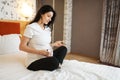 Pregnant woman with belly takes pills in bed Royalty Free Stock Photo