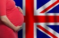 Pregnant woman belly on United Kingdom flag background Royalty Free Stock Photo