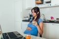 Pregnant woman with belly working as freelancer with laptop. Indoors, life