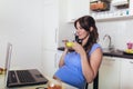 Pregnant woman with belly working as freelancer with laptop