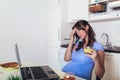 Pregnant woman with belly working as freelancer with laptop