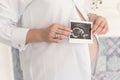 A pregnant woman with a big belly in a white shirt is holding a Royalty Free Stock Photo