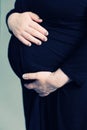 Pregnant woman in black dress holds her stomach Royalty Free Stock Photo