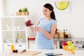 Pregnant woman with blender cup and glass at home Royalty Free Stock Photo