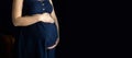 pregnant woman in a blue dress on a dark isolated background banner Royalty Free Stock Photo