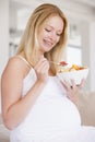 Pregnant woman with bowl of fruit salad smiling Royalty Free Stock Photo