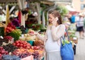 Pregnant woman calling on smartphone at market Royalty Free Stock Photo