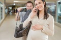 Pregnant woman chats burdened husband follows behind