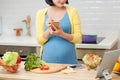 Pregnant woman checking and making shopping list before going to grocery store Royalty Free Stock Photo