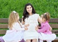 Pregnant woman and children in summer city park outdoor, happy family, bright sunny day and green grass, beautiful people portrait Royalty Free Stock Photo