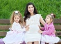 Pregnant woman and children in summer city park outdoor, happy family, bright sunny day and green grass, beautiful people portrait Royalty Free Stock Photo