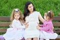 Pregnant woman and children in summer city park outdoor, happy family, bright sunny day and green grass, beautiful people portrait Royalty Free Stock Photo