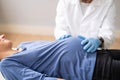 Pregnant Woman At Chiropractor. Baby Breech Physiotherapy