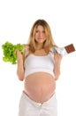 Pregnant woman with chocolate and lettuce Royalty Free Stock Photo