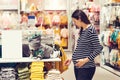 Pregnant woman chooses clothes for her future son. Pregnancy and shopping. Young mother doing shopping in baby shop Royalty Free Stock Photo