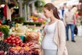 Pregnant woman choosing food at street market
