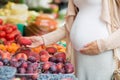 Pregnant woman choosing fruits at street market Royalty Free Stock Photo