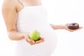 Pregnant woman choosing healthy apple over unhealthy donut Royalty Free Stock Photo