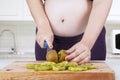 Pregnant woman chopping kiwi fruit Royalty Free Stock Photo