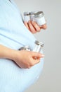 Pregnant woman with containers for urine samples