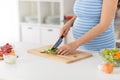 Pregnant woman cooking vegetable salad at home Royalty Free Stock Photo