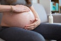 Pregnant woman on a couch in living room