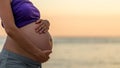 Pregnant woman cradling her belly with her hands Royalty Free Stock Photo