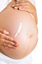 Pregnant woman creaming belly