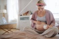 Pregnant woman creaming her belly, taking care of herself.