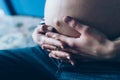 Pregnant woman cuddling belly in bedroom at home just before the labor and childbirth, selective focus Royalty Free Stock Photo