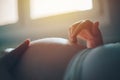 Pregnant woman cuddling belly in bedroom at home Royalty Free Stock Photo