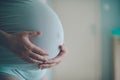 Pregnant woman cuddling belly in bedroom at home Royalty Free Stock Photo