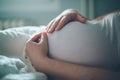 Pregnant woman cuddling belly in bedroom at home Royalty Free Stock Photo