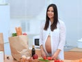 Pregnant woman cuts vegetables for a salad standing in the kitchen Royalty Free Stock Photo