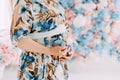 Pregnant woman in delicate blue dress stroking her belly Royalty Free Stock Photo