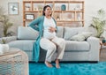 Pregnant woman, discomfort and back pain sitting on the living room sofa and holding tummy at home. Female going through Royalty Free Stock Photo